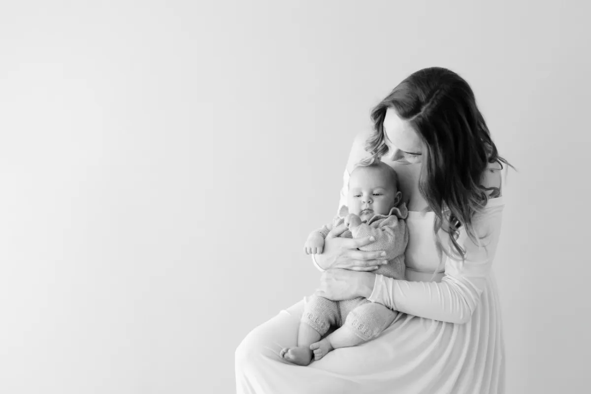 Maman tenant son nouveau-né contre elle, portrait en noir et blanc